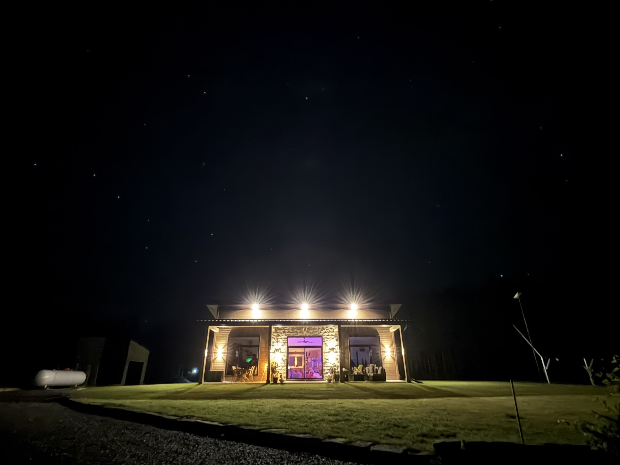 La maison OFFGRID illuminée sous les étoiles